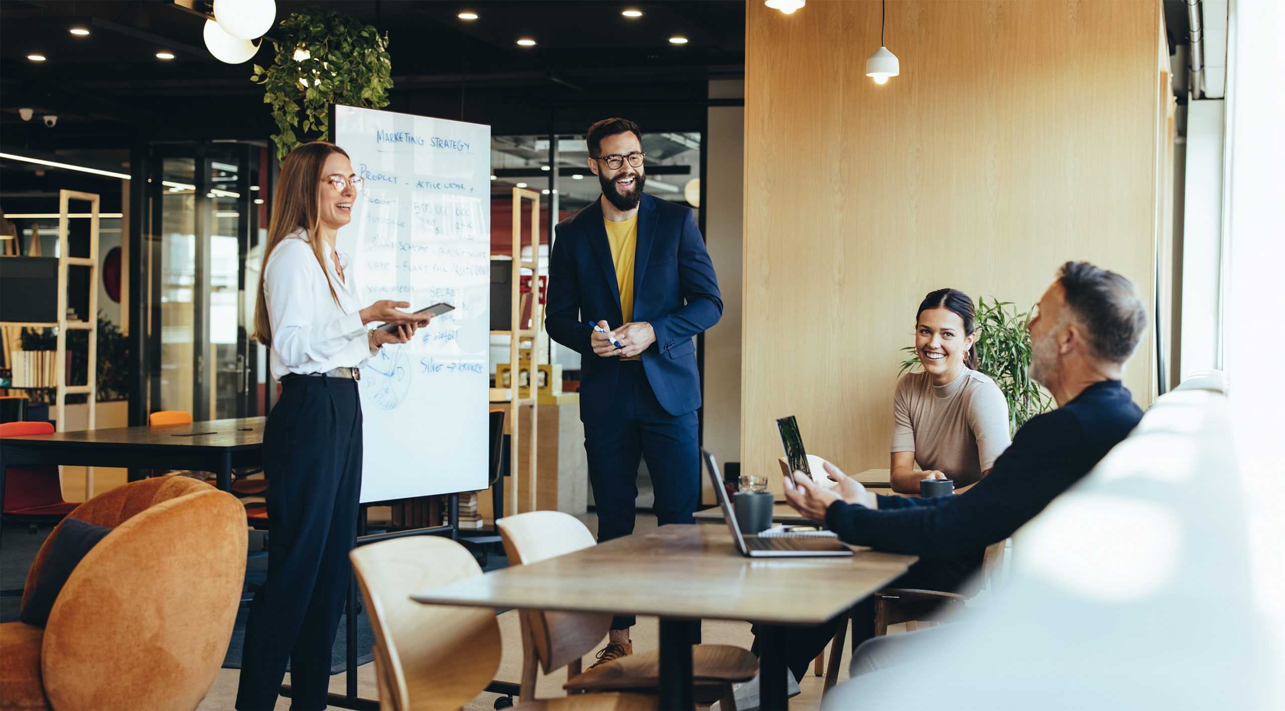 two happy men and two happy women in a business meeting discussing corvel risk management services