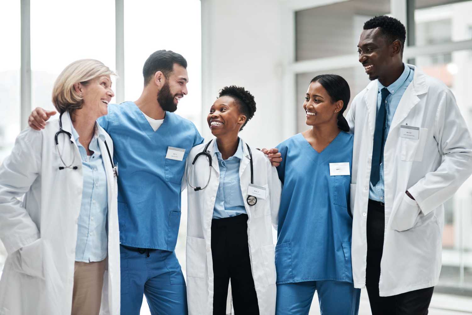 happy group of male and female nurses and doctors in CorVel's provider network standing together