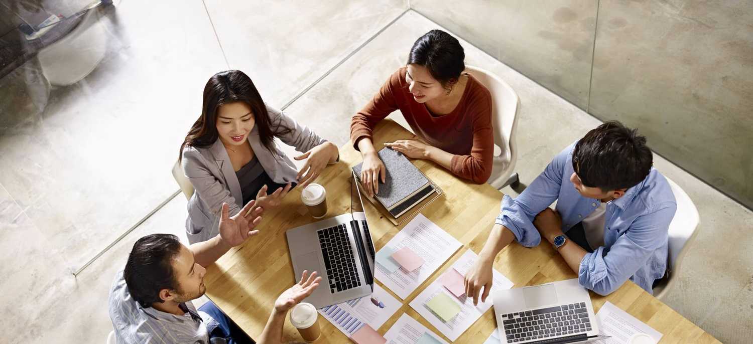 Professionals sitting around a table enjoying corvel's great place of opportunity