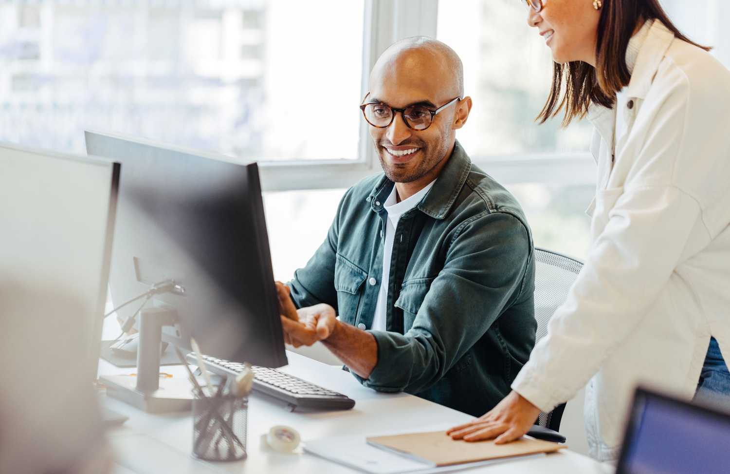 Two MSIG North America colleagues looking and smiling at a computer screen