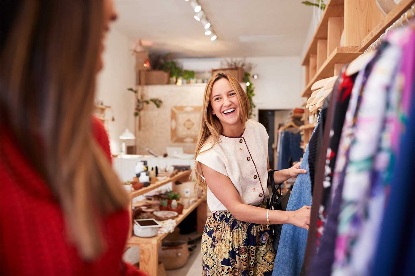 two happy women shopping in a retail clothing store