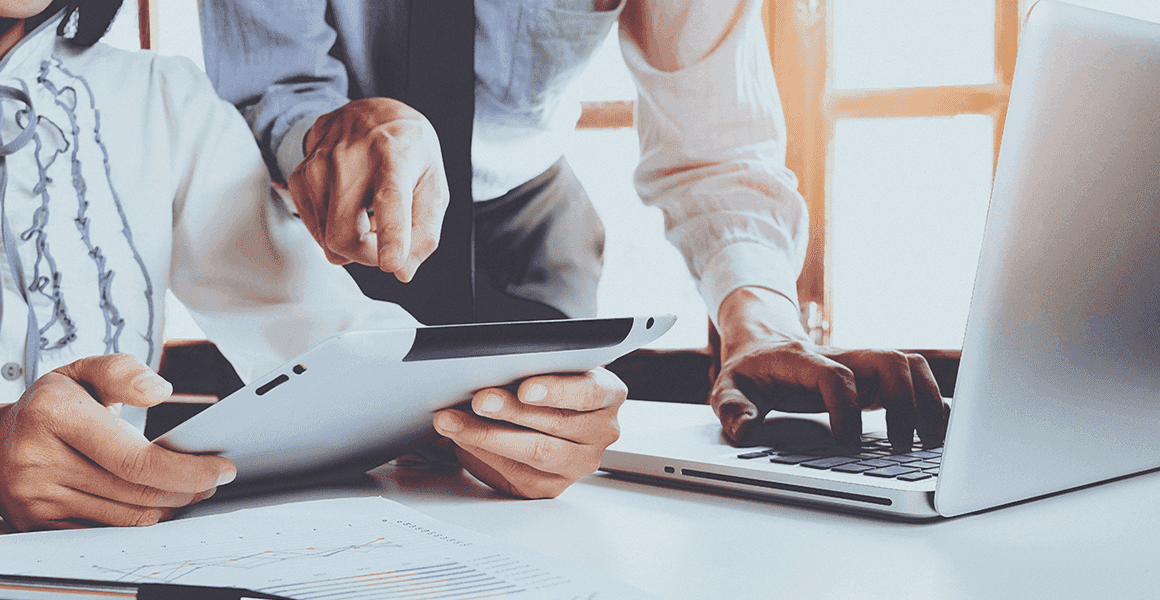 Two people looking at a bill review report on a tablet