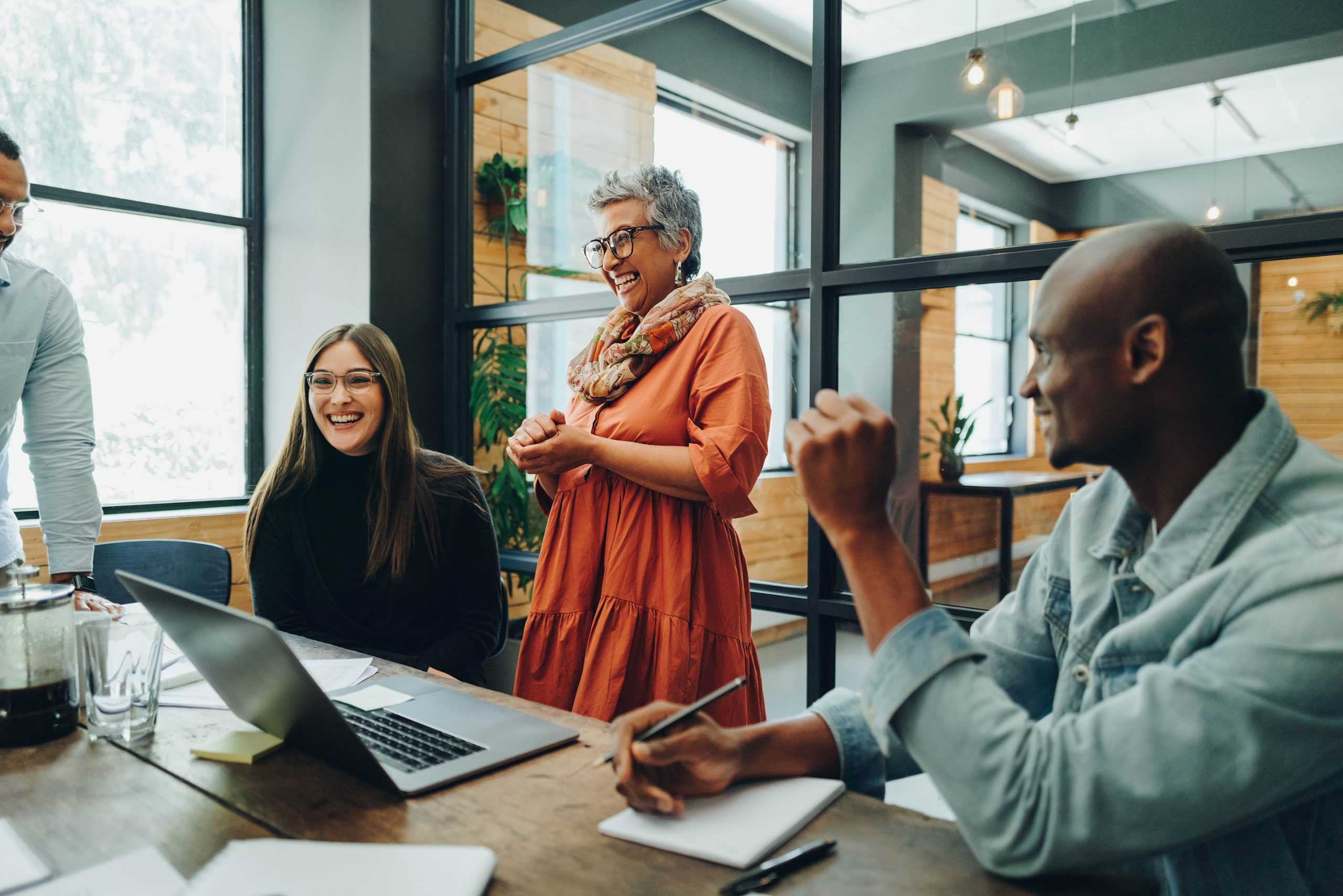 a happy group of CorVel employees sitting around a meeting table