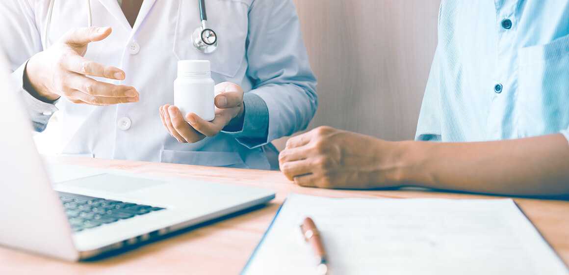 A doctor holding a medication, talking to a patient about curbing chronic pain