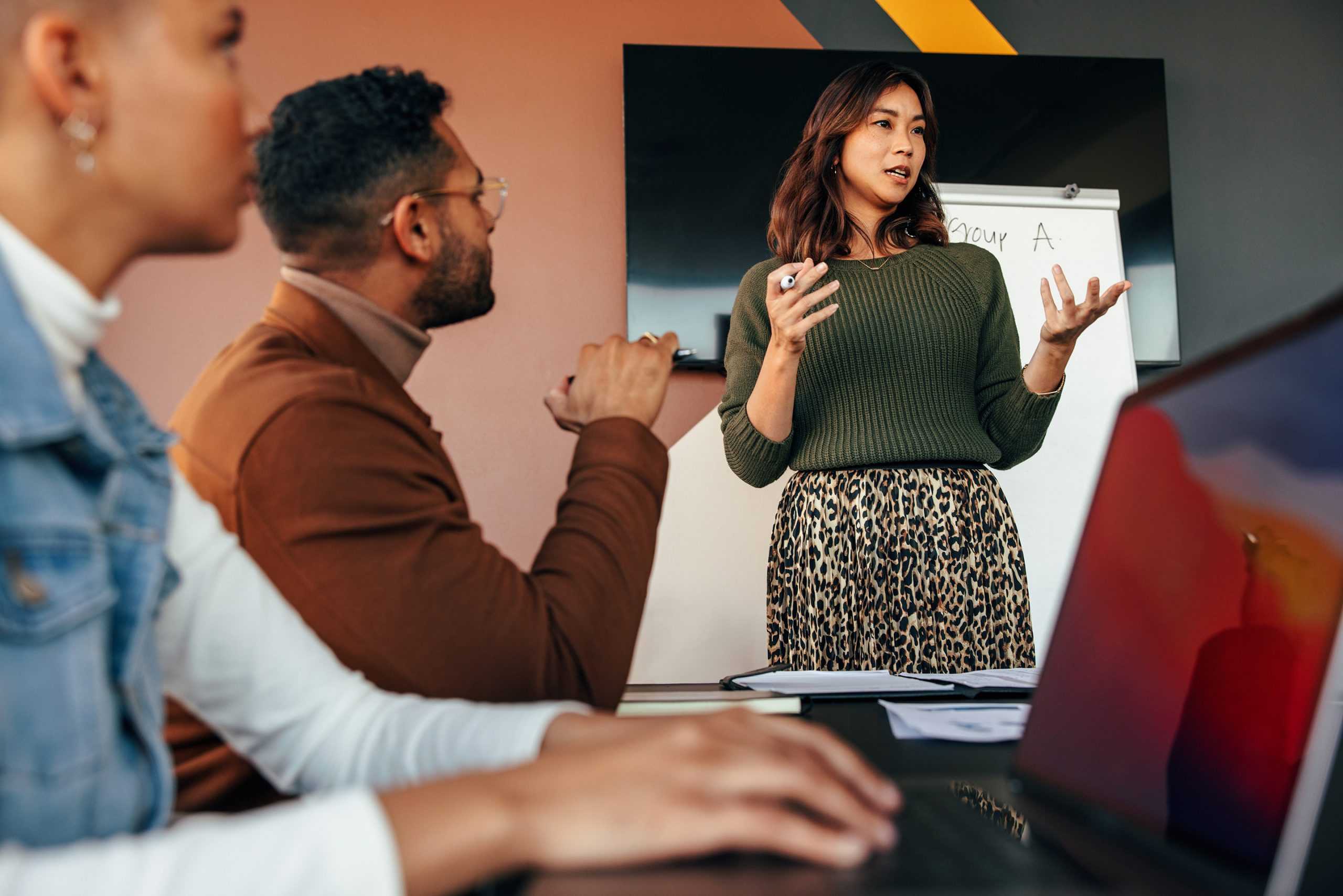 businesswoman leading a meeting with colleagues discussing workers comp liability services