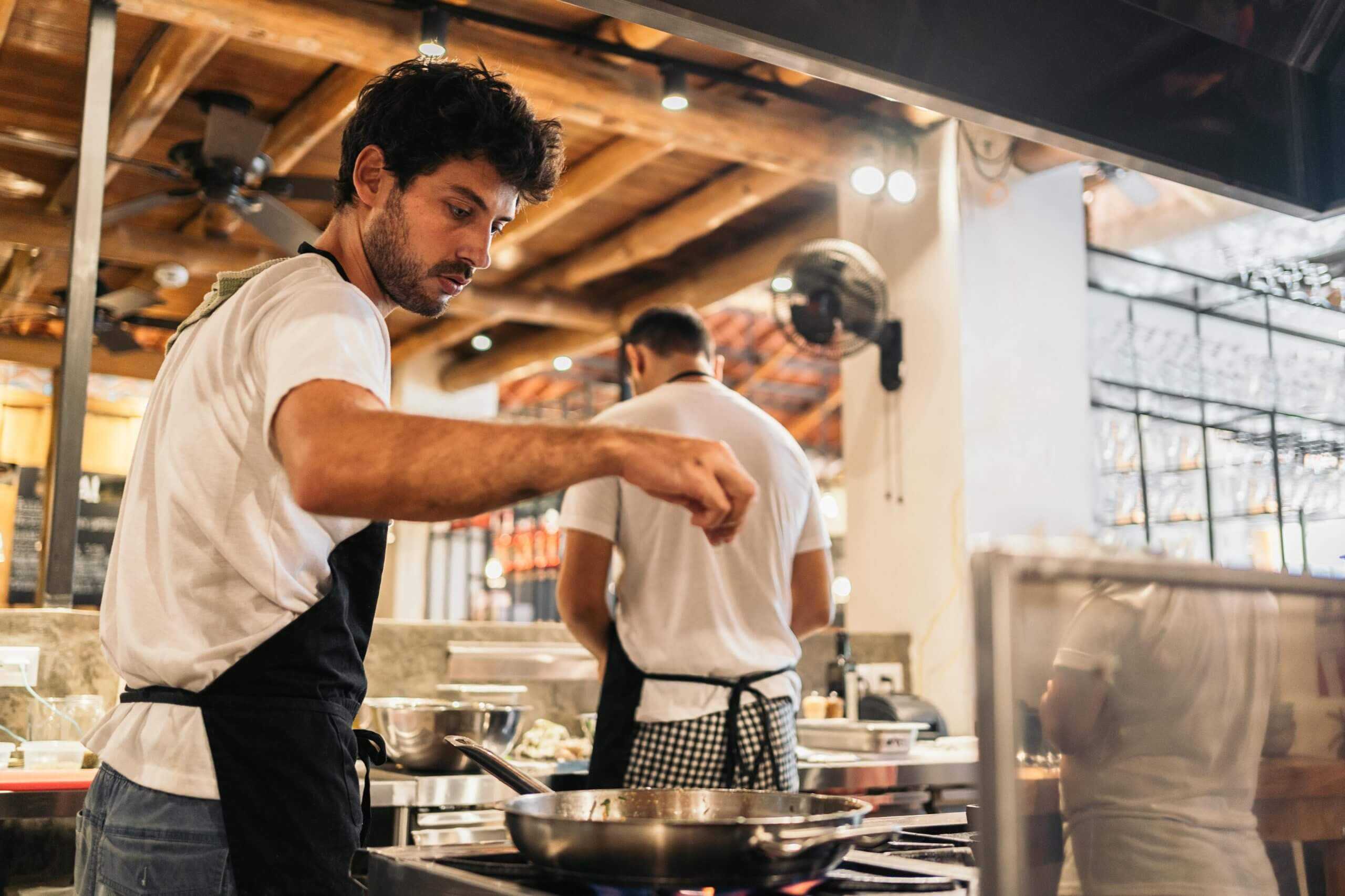 a male cook working in a kitchen protected by corvel's workers comp case management services