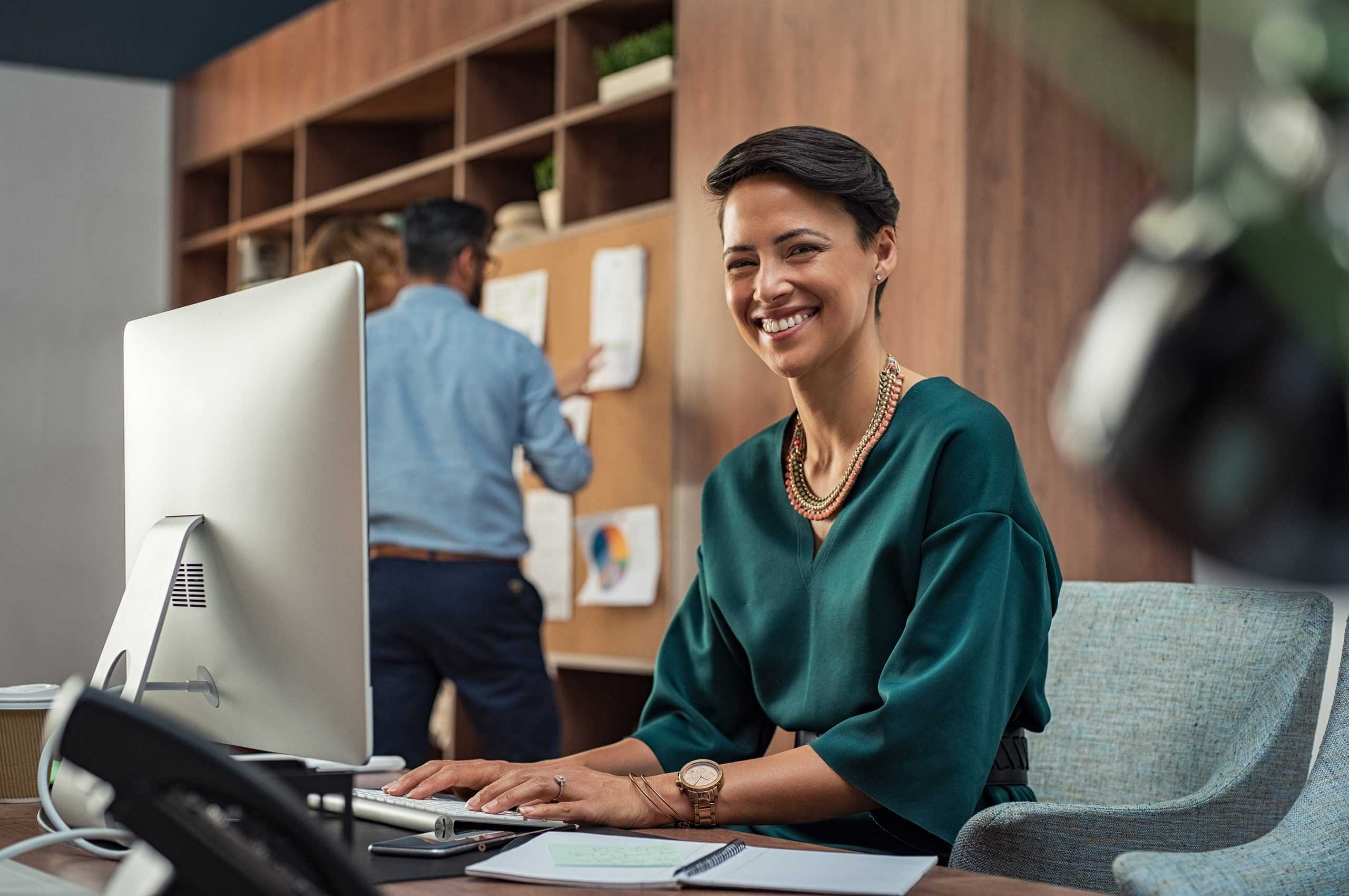 a happy female life care planner working on her computer in an office