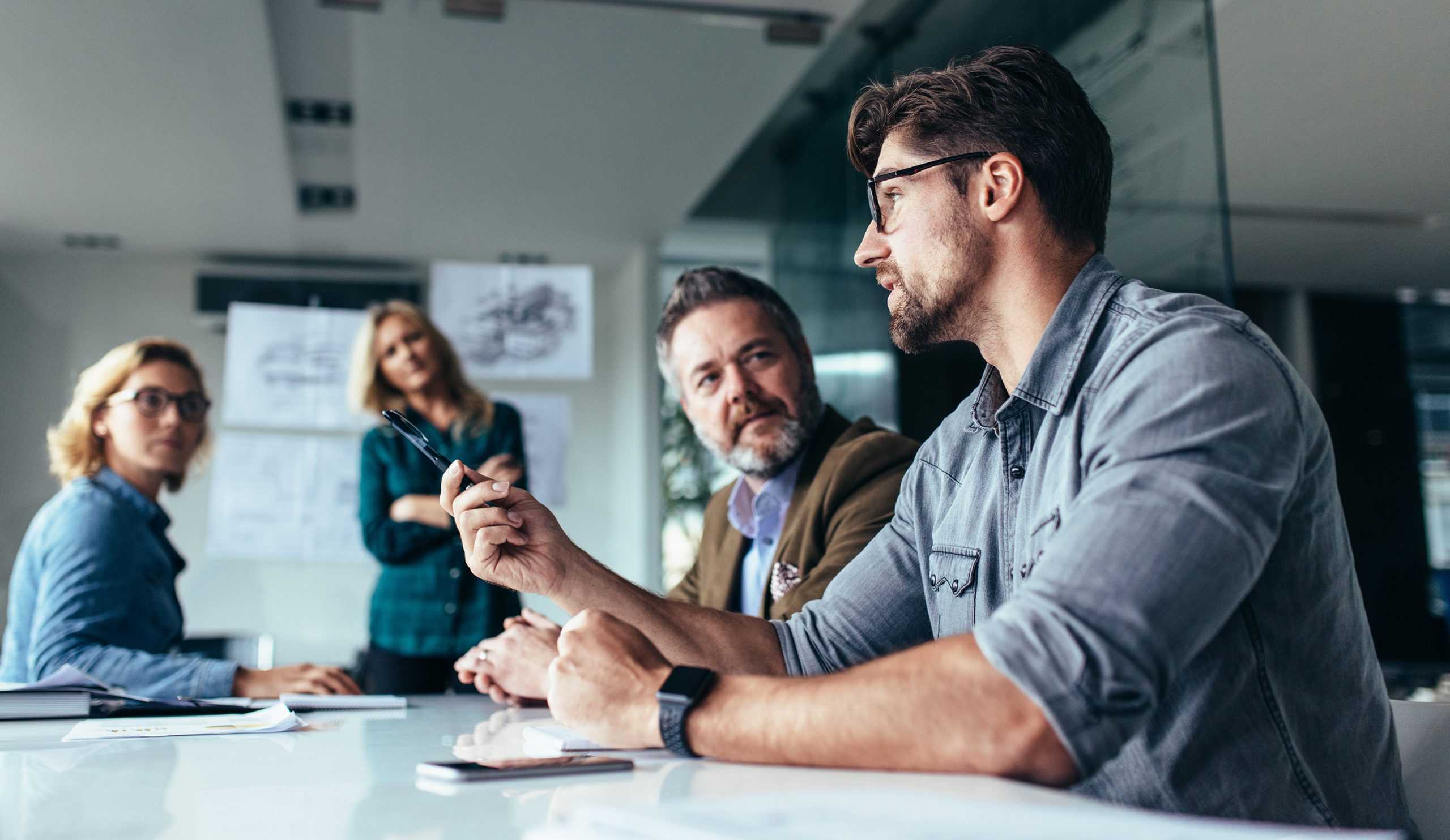 male professional meeting with two colleagues discussing corvel's general liability services