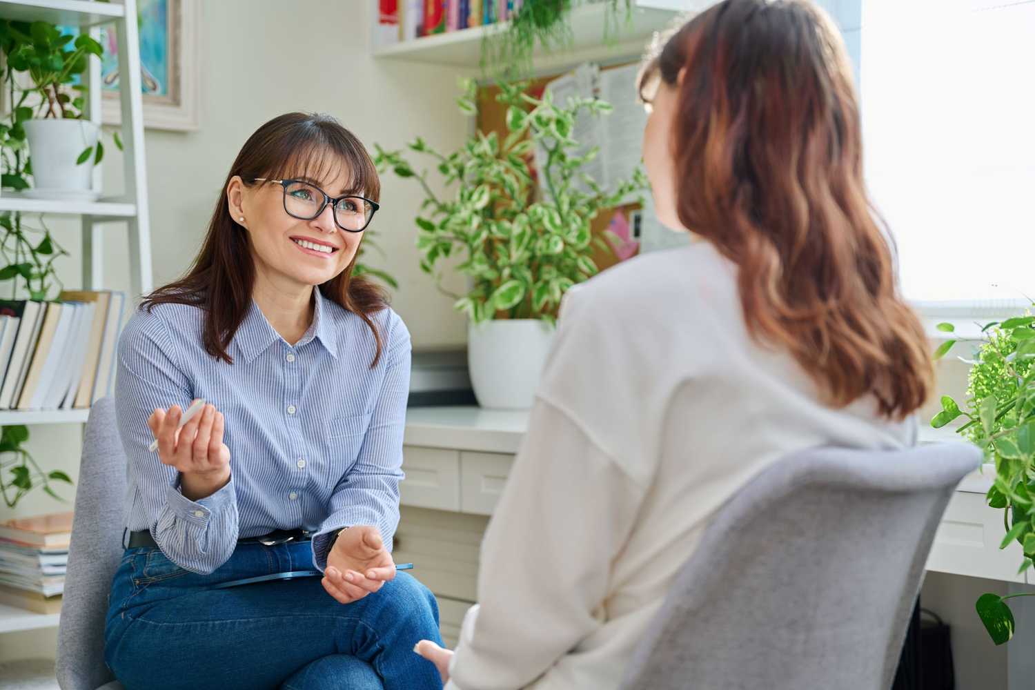Female psychologist, counselor working with young woman, therapy in office