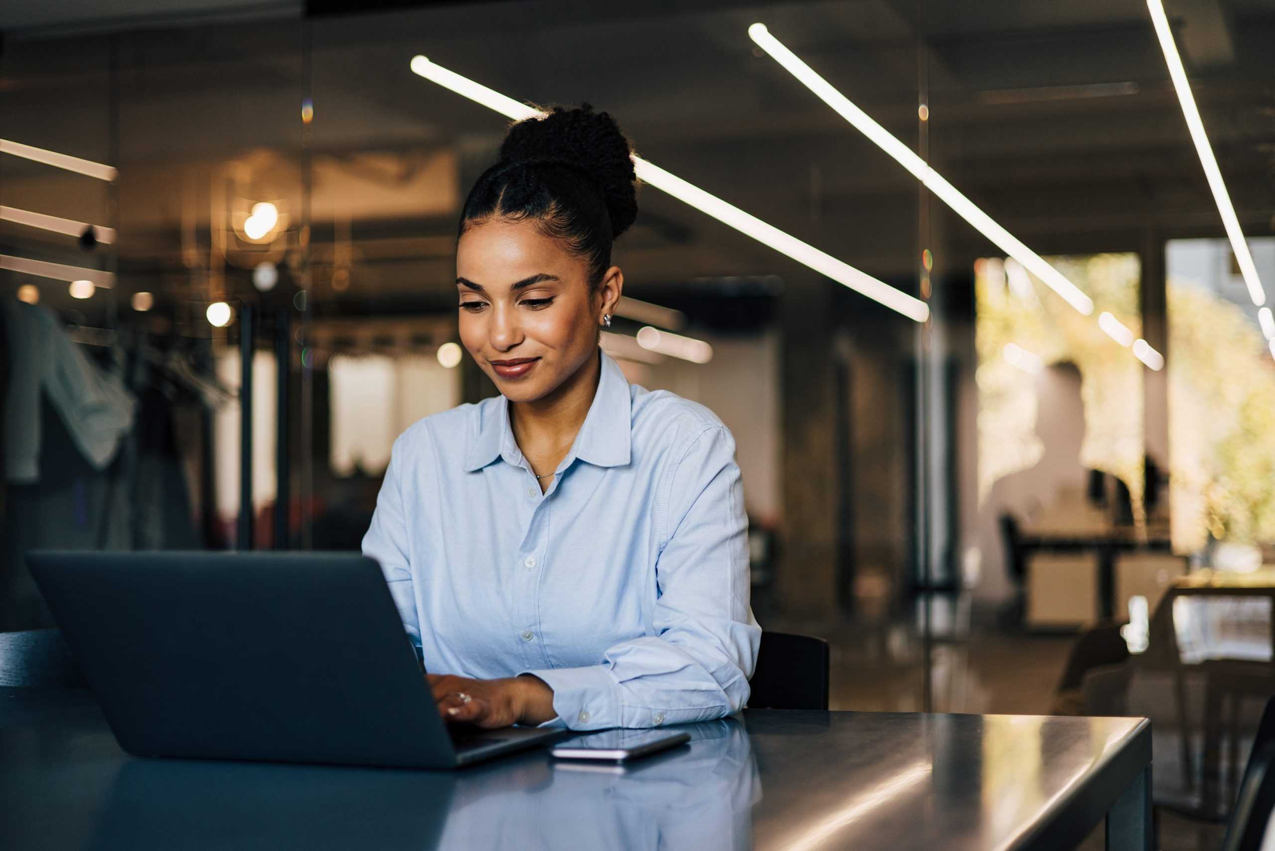 a smiling businesswoman on a computer learning about corvel's workers comp utilization review management